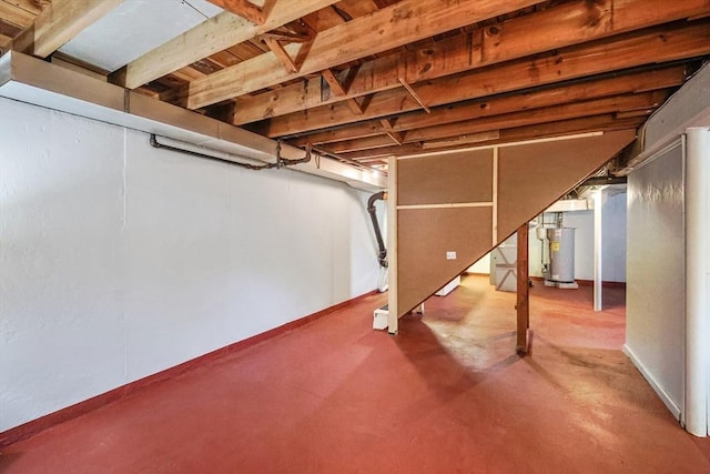 unfinished basement with water heater and stairway