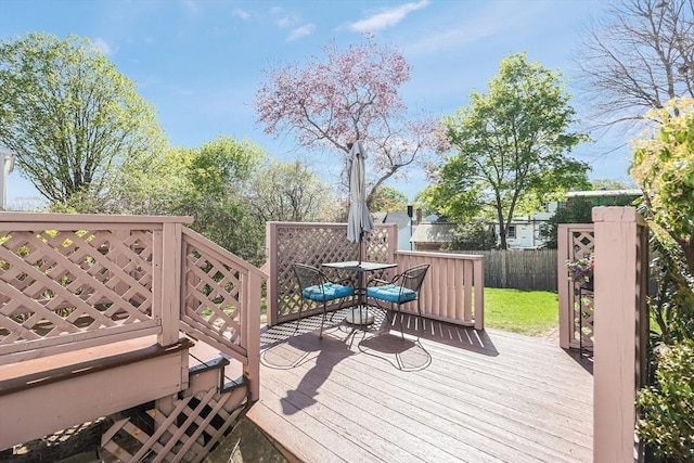 wooden terrace featuring fence and outdoor dining space