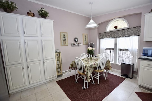 dining area with baseboards, light tile patterned floors, and crown molding