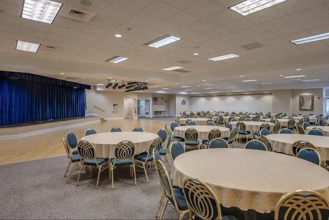 dining space with visible vents, carpet floors, and a paneled ceiling