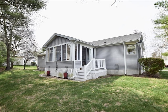 back of house with a yard and a sunroom