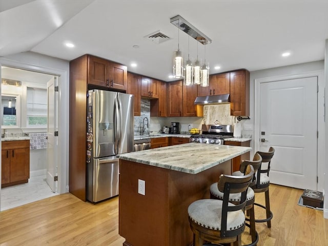 6 Nelly St Unit 3, Wakefield, MA 01880 - kitchen with stainless steel appliances, under cabinet range hood, a breakfast bar, pendant lighting, and recessed lighting