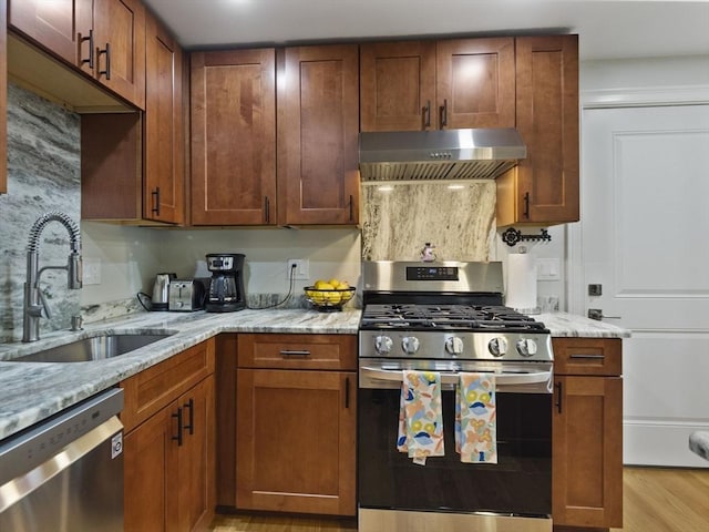 6 Nelly St Unit 3, Wakefield, MA 01880 - kitchen with appliances with stainless steel finishes, ventilation hood, light wood-type flooring, light stone counters, and brown cabinets