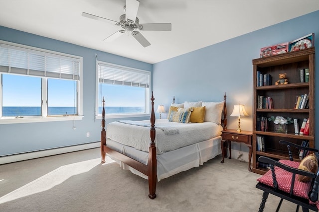 carpeted bedroom with a baseboard heating unit, a water view, and ceiling fan