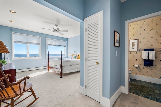 carpeted bedroom with a baseboard heating unit, a water view, and ceiling fan