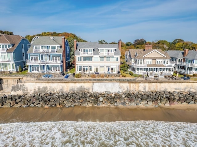 rear view of house with a balcony and a water view