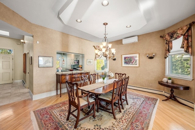 dining area with light hardwood / wood-style floors, a wall unit AC, a baseboard heating unit, and a chandelier