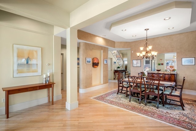 dining space with an inviting chandelier and light hardwood / wood-style floors