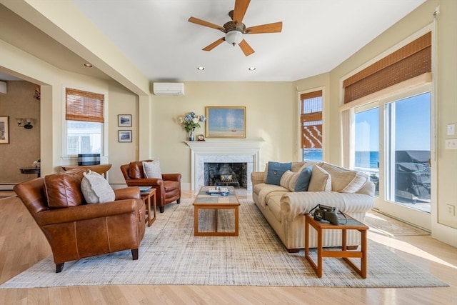 living room featuring a baseboard radiator, light hardwood / wood-style flooring, a healthy amount of sunlight, and ceiling fan