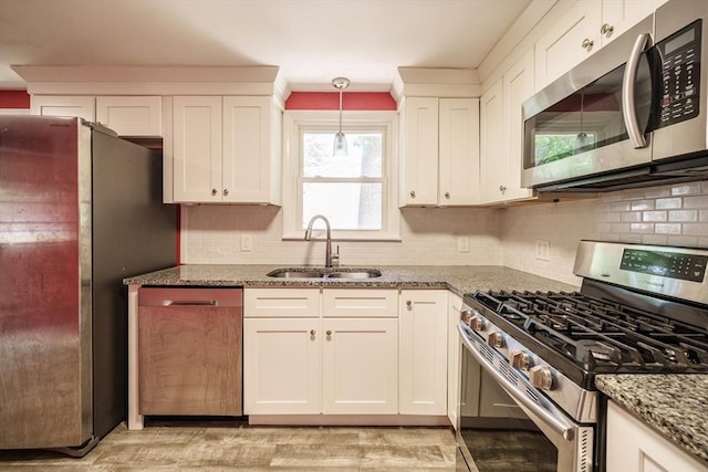 226 Dutchess St, Springfield, MA 01129 - kitchen featuring stainless steel appliances, a sink, light stone counters, tasteful backsplash, and white cabinetry