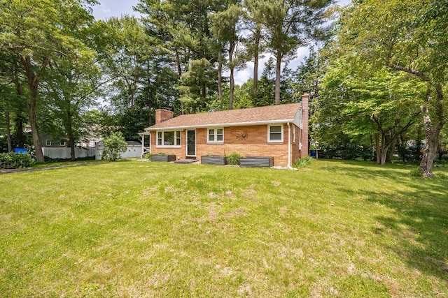 226 Dutchess St, Springfield, MA 01129 - view of front of house featuring a chimney, a front yard, brick siding, and view of wooded area