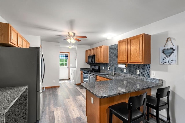 43 Outlook Rd, Billerica, MA 01862 - kitchen with stainless steel appliances, washer and dryer, a peninsula, ceiling fan, and tasteful backsplash