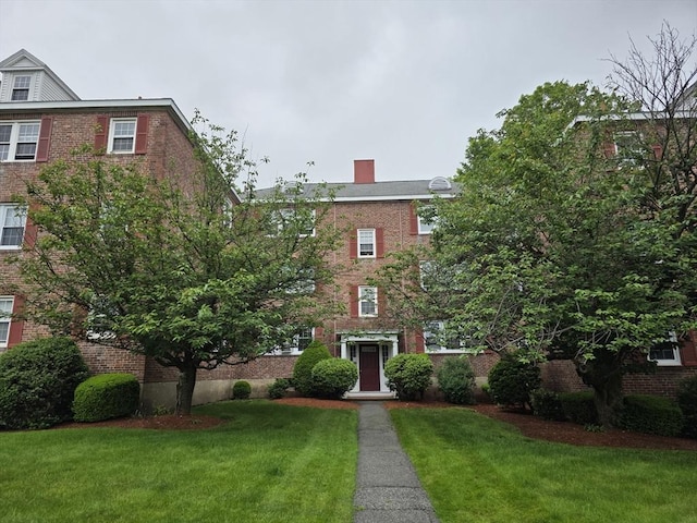 5 Dexter St Unit 6, Malden, MA 02148 - view of front of property with brick siding, a front yard, and a chimney