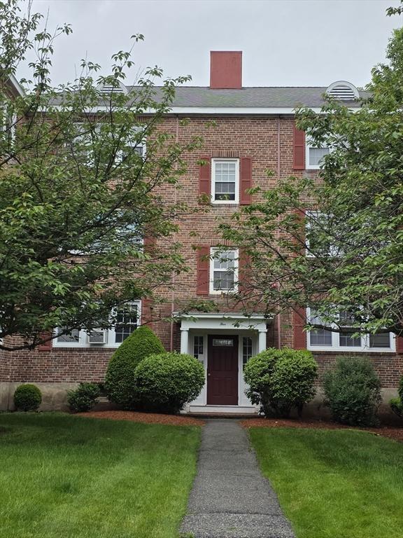 5 Dexter St Unit 6, Malden, MA 02148 - view of front of house featuring brick siding, a front yard, and a chimney