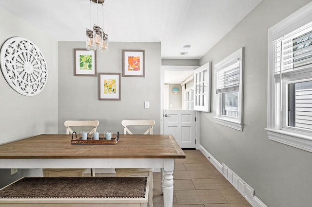dining area featuring a chandelier, baseboards, and visible vents