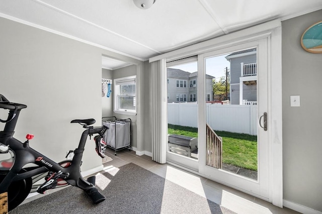 exercise room with crown molding, tile patterned floors, plenty of natural light, and baseboards