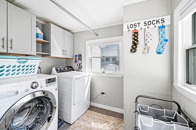 washroom featuring cabinet space, wood finish floors, baseboards, and washer and dryer