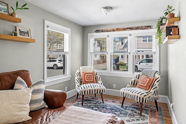 living area featuring baseboards and wood finished floors