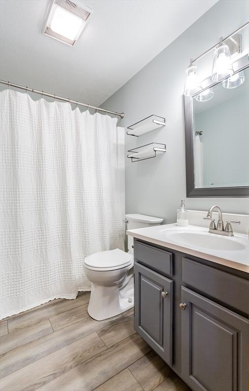 145 Reservoir St, Norton, MA 02766 - full bath with toilet, vanity, wood finished floors, and a shower with curtain