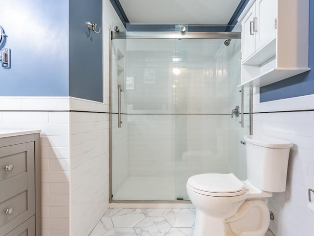 145 Reservoir St, Norton, MA 02766 - bathroom with tile walls, toilet, a stall shower, vanity, and a wainscoted wall