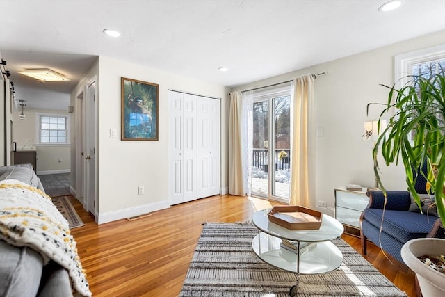 living area featuring light wood finished floors, baseboards, and recessed lighting