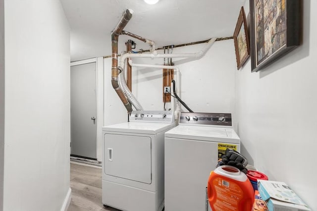 washroom featuring laundry area, light wood-style flooring, and washer and dryer