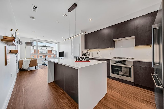 99 Sumner Unit 514, Boston, MA 02128 - kitchen with appliances with stainless steel finishes, light countertops, open floor plan, dark wood-type flooring, and pendant lighting