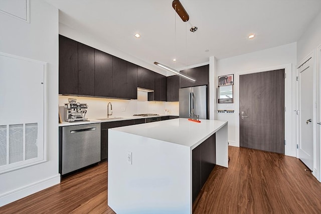 99 Sumner Unit 514, Boston, MA 02128 - kitchen with appliances with stainless steel finishes, a sink, dark wood finished floors, a kitchen island, and light countertops
