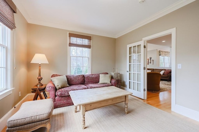 living area with light wood finished floors, baseboards, french doors, and ornamental molding