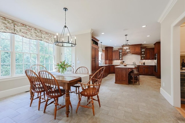 dining space featuring an inviting chandelier, crown molding, baseboards, and recessed lighting