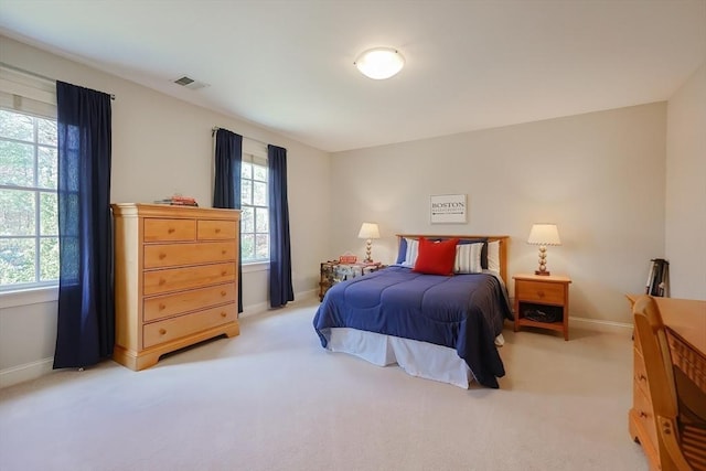 bedroom with baseboards, visible vents, multiple windows, and light carpet
