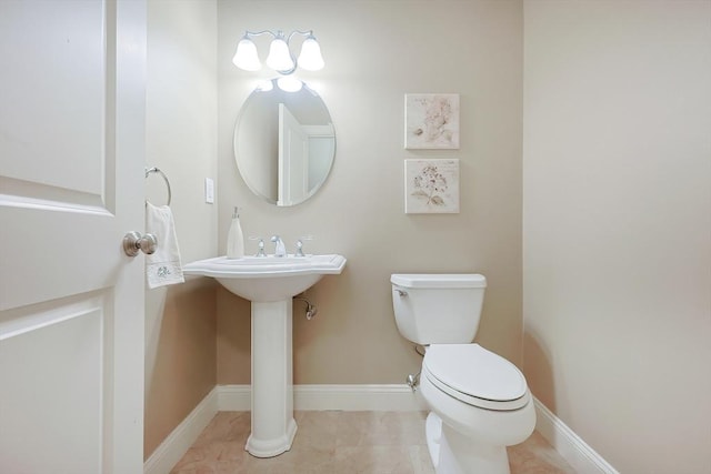 bathroom with tile patterned floors, toilet, and baseboards