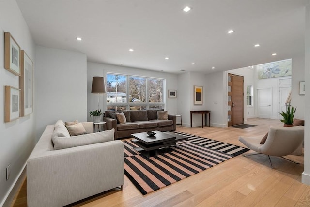 living area featuring light wood finished floors, baseboards, and recessed lighting