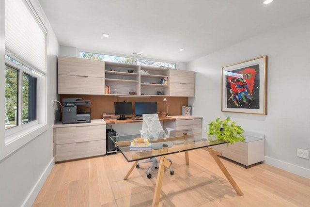 office area featuring light wood-style flooring, a wealth of natural light, and baseboards