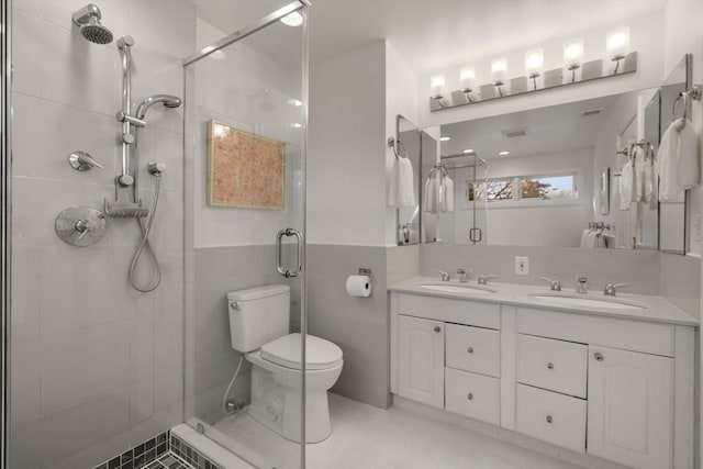 bathroom with a sink, a shower stall, toilet, and double vanity