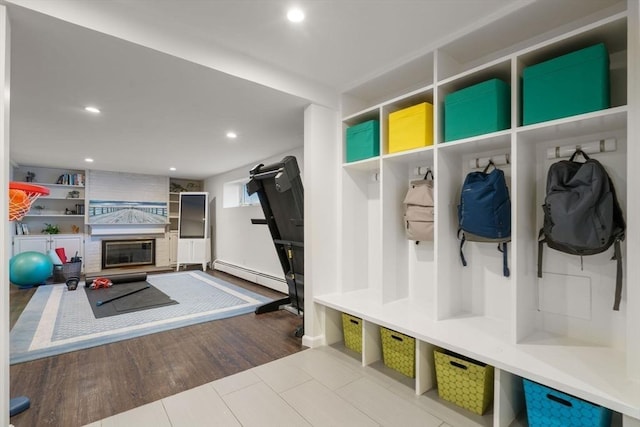 mudroom with wood finished floors, a baseboard radiator, a fireplace, and recessed lighting