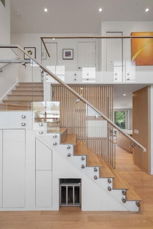 stairway with recessed lighting and wood finished floors