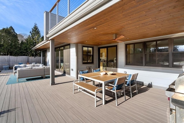 wooden deck featuring outdoor dining area, fence, and an outdoor living space