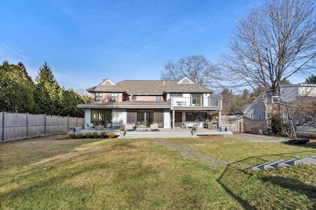 rear view of house featuring a balcony, a fenced backyard, and an outdoor hangout area