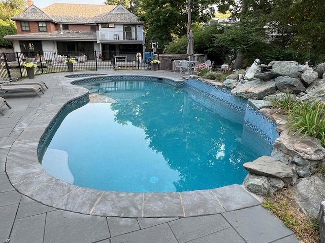 view of swimming pool featuring a patio area, fence, and a fenced in pool