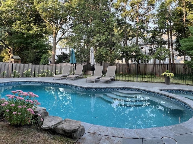 view of swimming pool with a hot tub, fence, a fenced in pool, and a patio