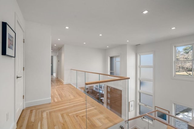 hallway with attic access, recessed lighting, baseboards, and an upstairs landing