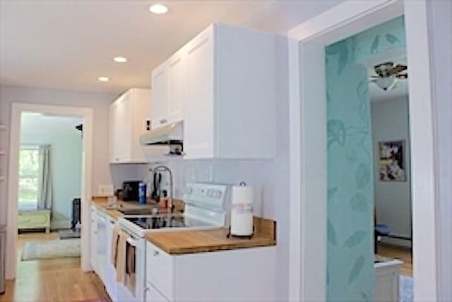 374 Swains Pond Ave, Melrose, MA 02176 - kitchen with white electric range, under cabinet range hood, white cabinets, recessed lighting, and light countertops