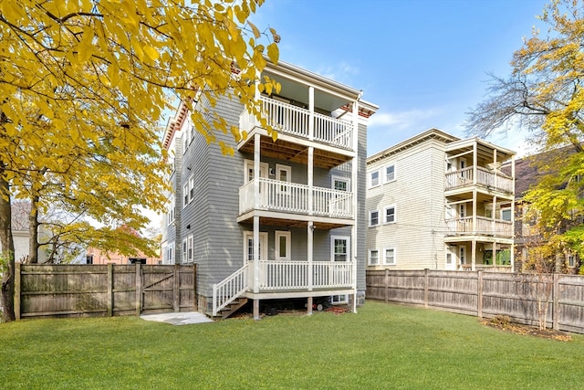 rear view of property featuring a lawn and a balcony