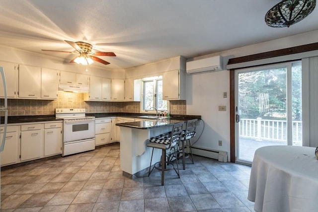 kitchen with white range with electric cooktop, a baseboard heating unit, a wall mounted AC, white cabinets, and kitchen peninsula