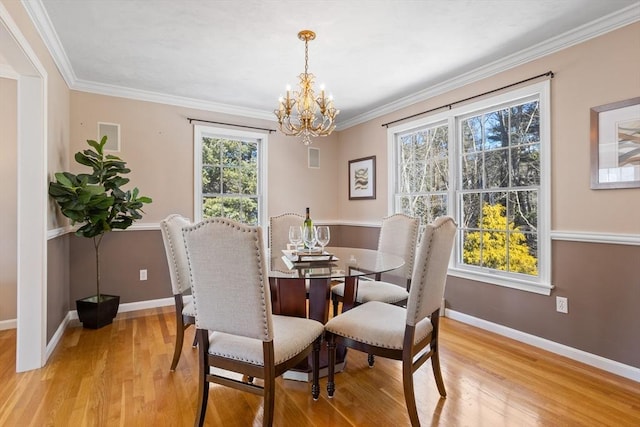 dining area featuring light wood-type flooring, baseboards, and ornamental molding