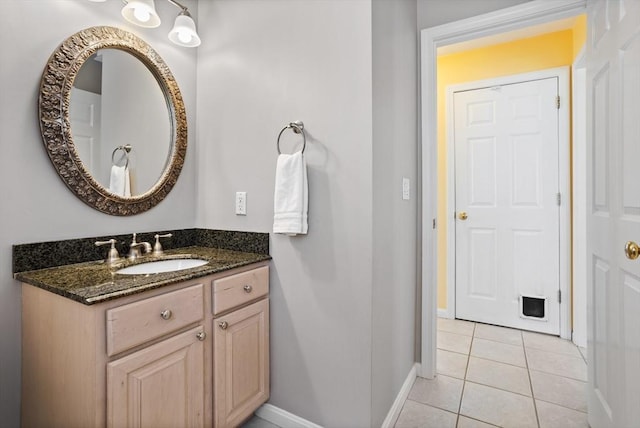 bathroom featuring vanity, baseboards, and tile patterned floors