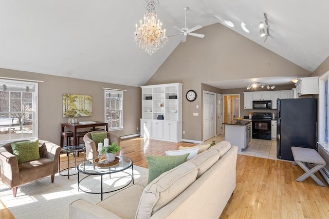 living area with a baseboard heating unit, high vaulted ceiling, light wood-style flooring, and baseboards