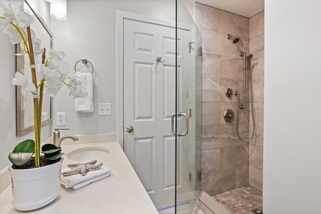 bathroom with a shower stall and vanity