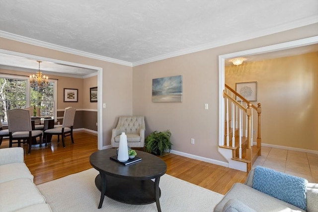 living room with a notable chandelier, crown molding, wood finished floors, baseboards, and stairs